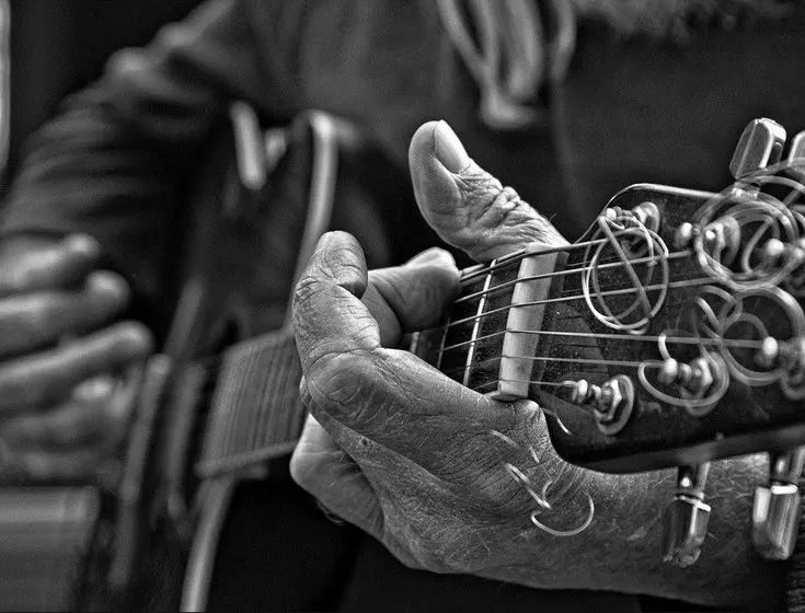 manos de anciano tocando la guitarra