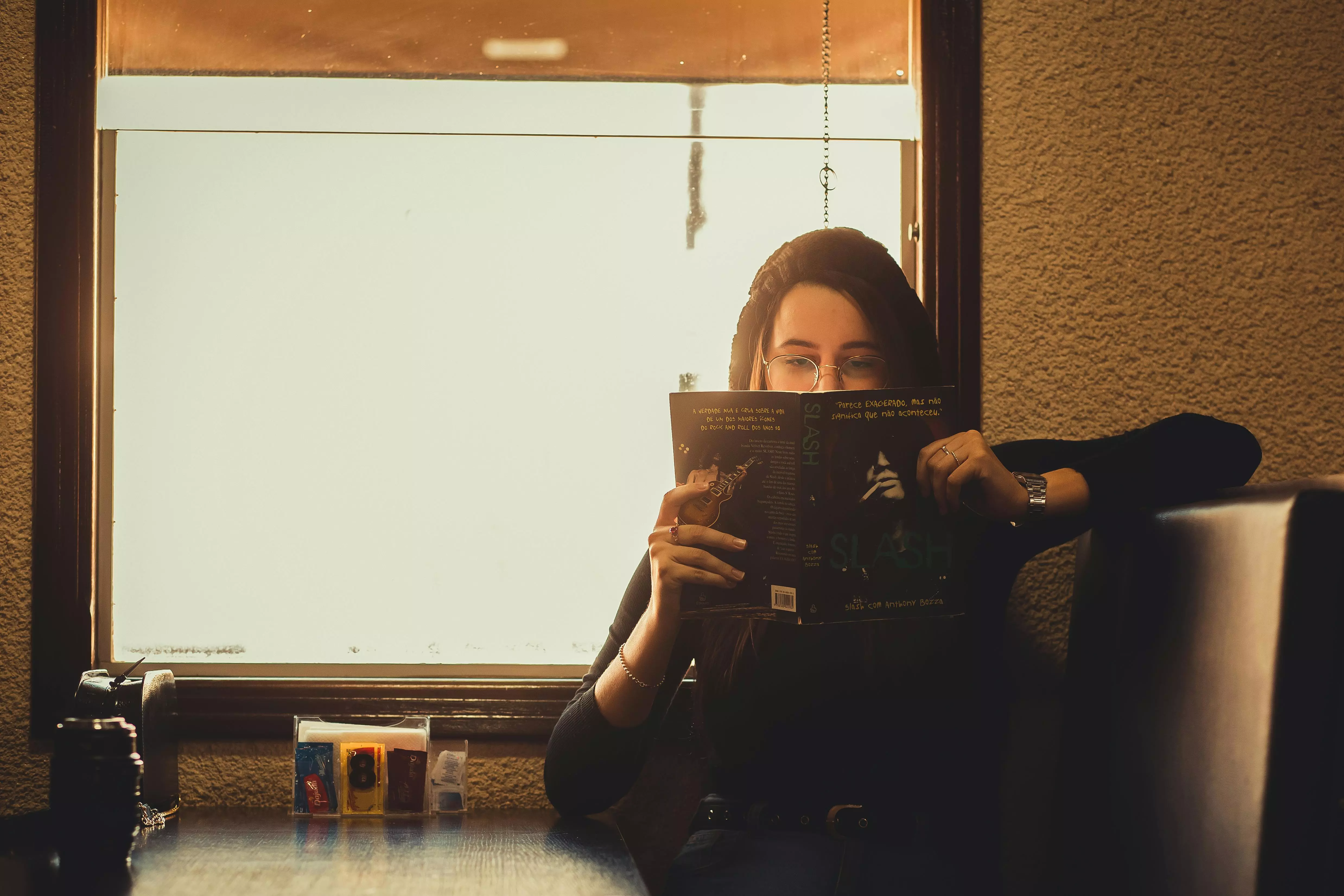 Chica leyendo en restaurante